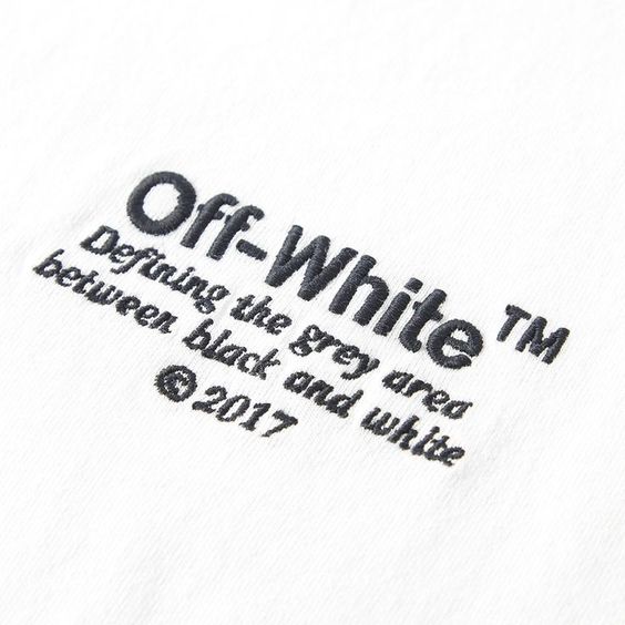Black-thread embroidered wordmark and script lettering on a white tee