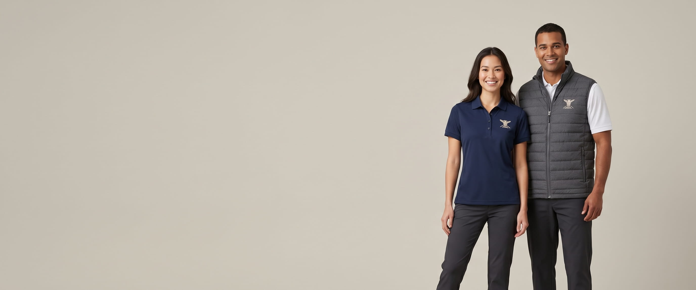 Two models with decorated CORE365 performance polos and puffer vest in a clean studio