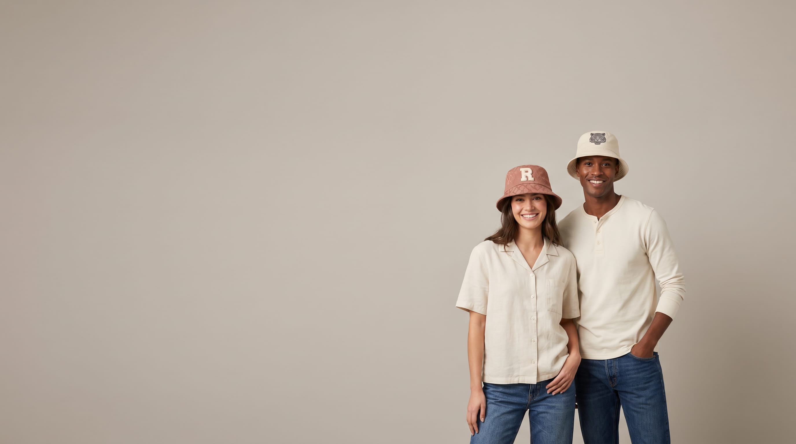 Two models wearing decorated Atlantis Headwear sustainable bucket hats in a clean studio
