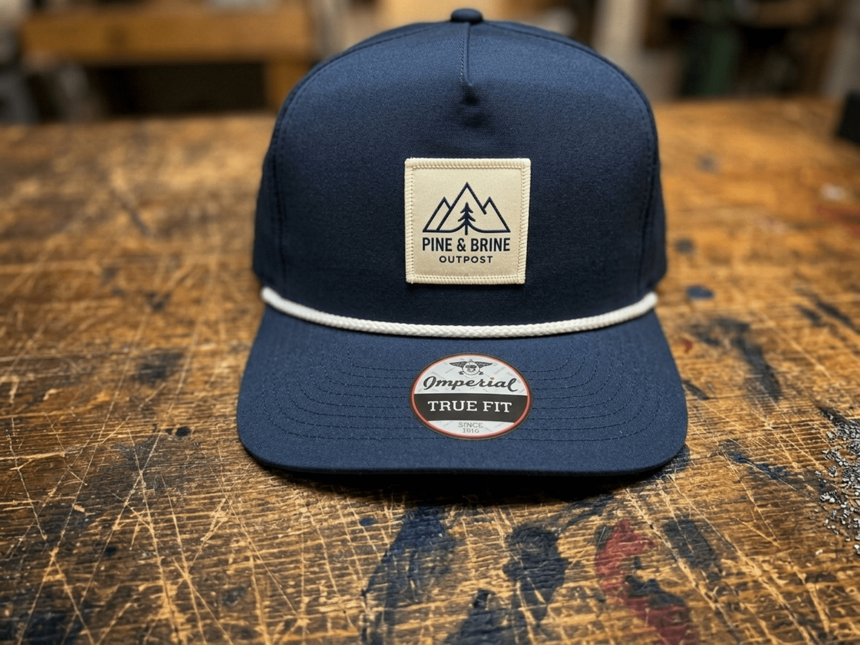Rope hat with custom sewn patch on front panel above braided cord