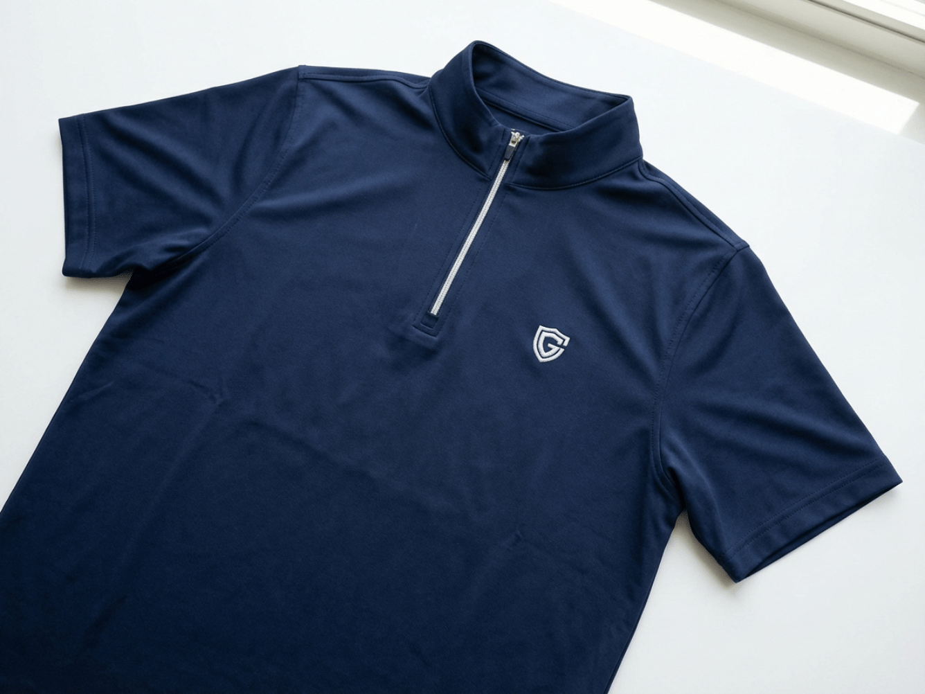 Embroidered logo on quarter-zip polo left chest