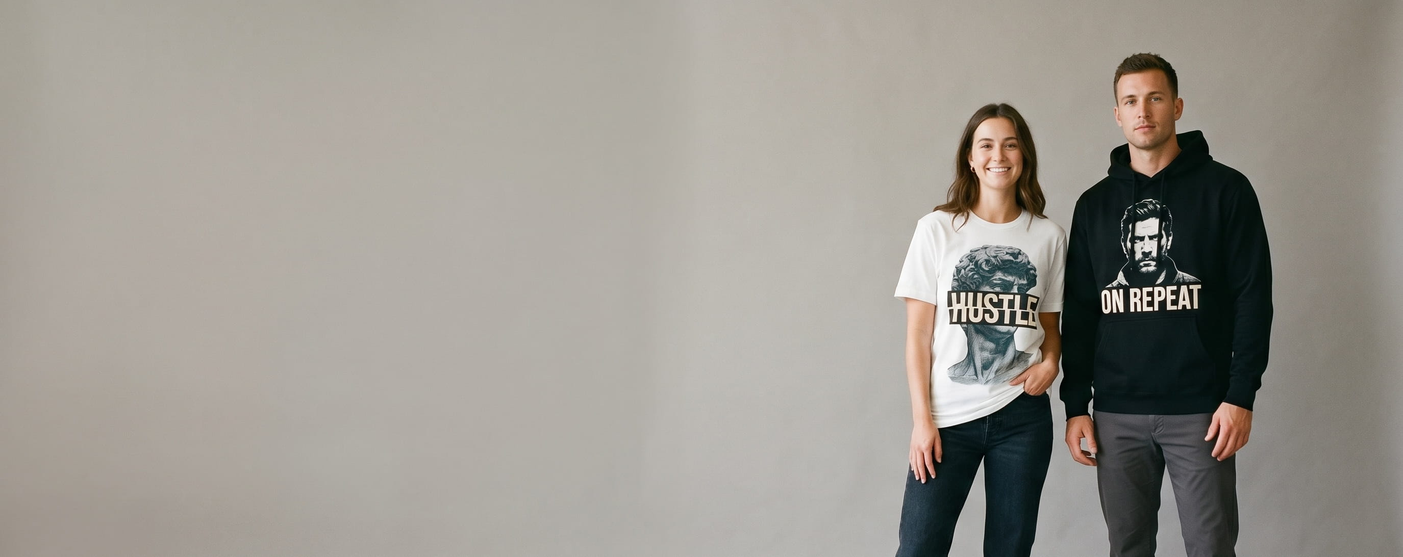 Two casual lifestyle models — woman in a white premium cotton crewneck with a full-chest vintage graffiti water-based screen print, man (athletic) in a black premium cotton hoodie with a full-chest DTG photographic print