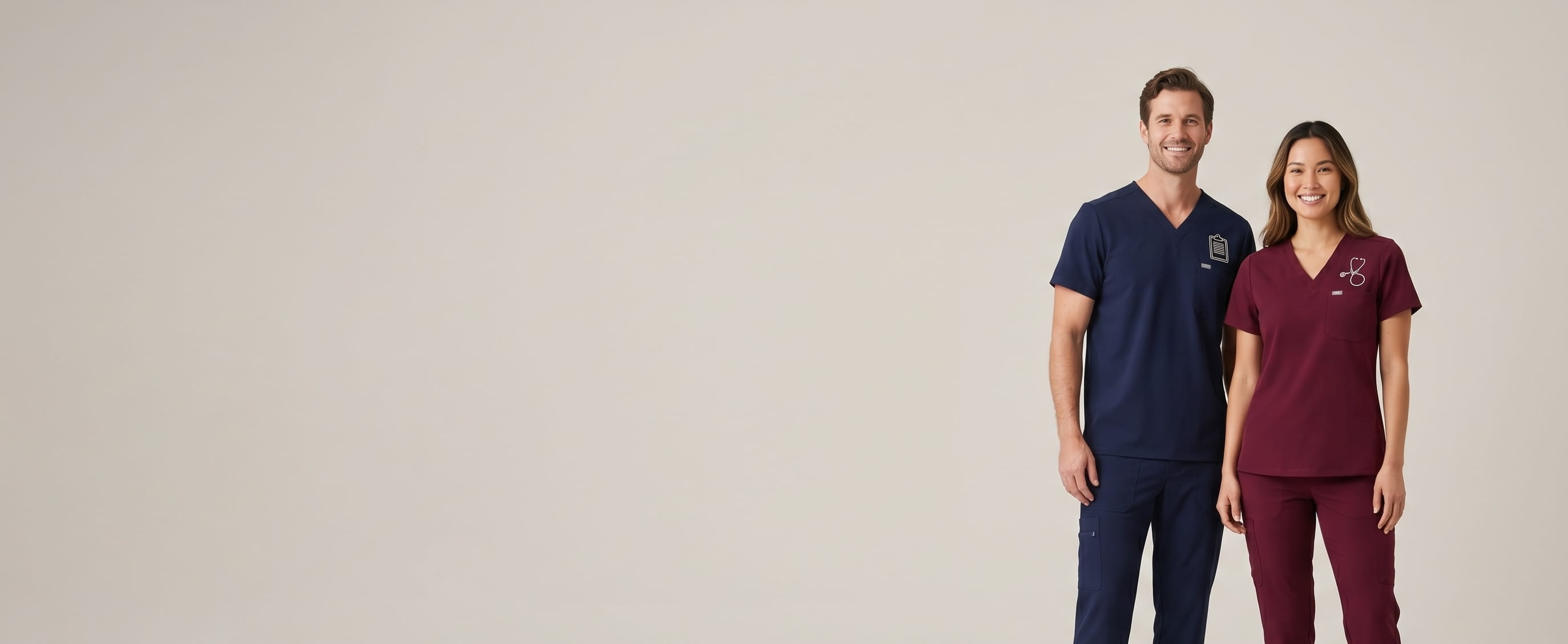 Two models with decorated Onna stretch medical scrubs in a clean studio