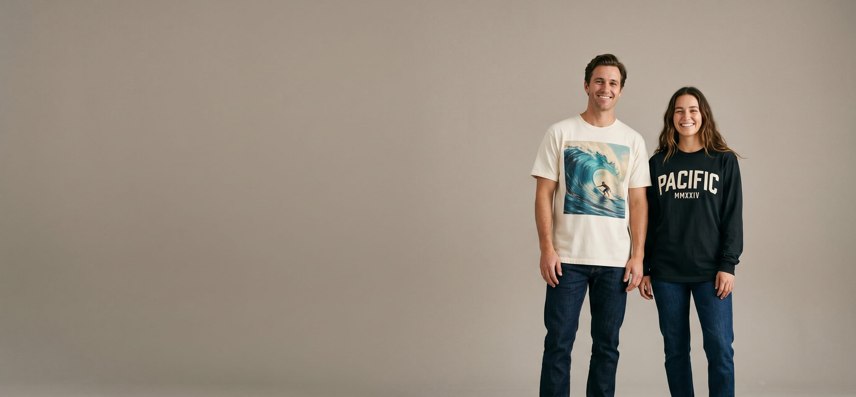 Two streetwear-lifestyle models wearing decorated Tultex pieces — full-color DTG ocean-wave illustration on the man's heavyweight street tee and bold "PACIFIC / MMXXIV" plastisol screen-print typography on the woman's heavyweight long-sleeve