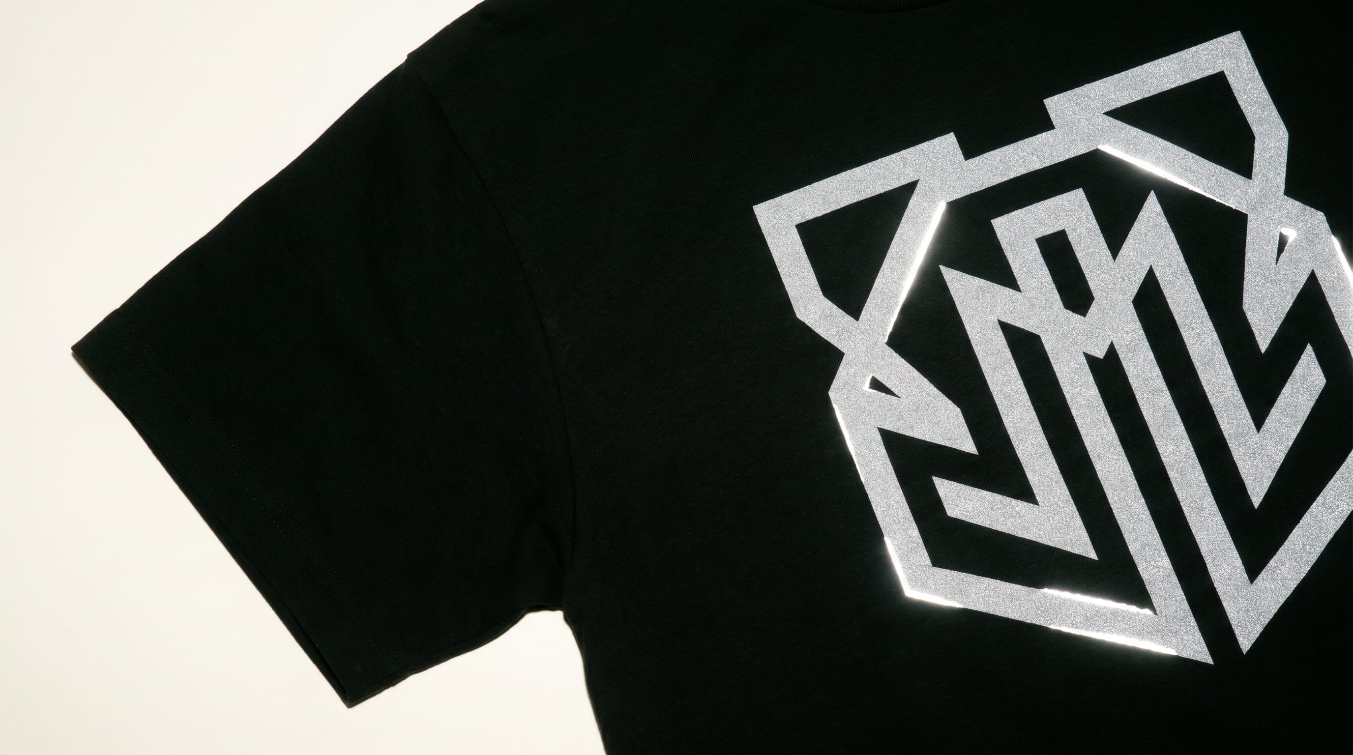 3M reflective screen print glowing bright on a t-shirt, hoodie, and jacket